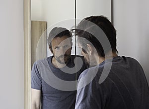 Man looking anxious in bathroom mirror