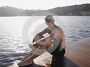 Man Looking Away While Sitting On Yacht's Floorboard