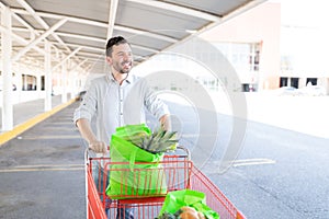 Man Looking Away While Standing With Shopping Cart
