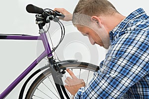 Man Looking At Bicycle Tire