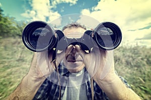 Man looking through binocular