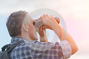 Man looking through binocular