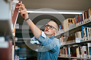 Man Looking For Book In Bookstore. Student In Library