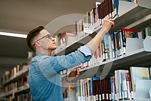 Man Looking For Book In Bookstore. Student In Library