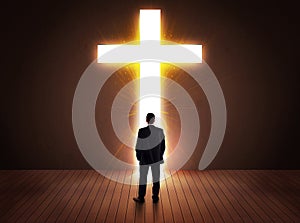 Man looking at bright cross sign