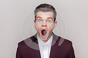 Man looking at camera with big eyes and open mouth sees something astonished.