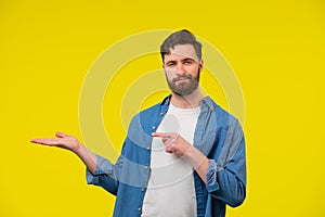 Man looking at the camera with open palm and pointing his finger at it
