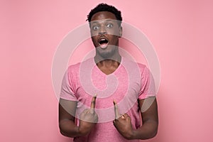 Man looking at camera pointing at himself with hands being surprised