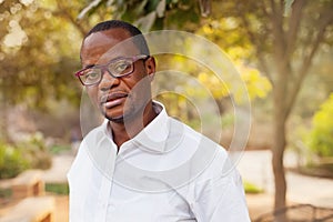 Man looking at camera standing in a park