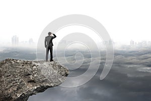 Man looking on cliff with gray cloudy sky cityscape background