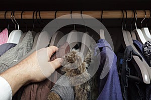 Man looking for clothes, rummaging in the cupboard