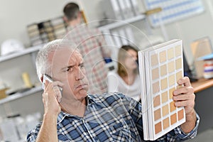Man looking at colour charts confused expression photo