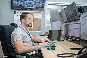 Man looking at computer screens sitting at keyboard