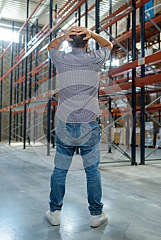 man looking in despair at empty racking in warehouse