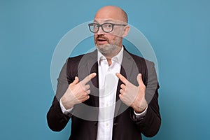 Man looking disappointedly at camera pointing at himself with hands