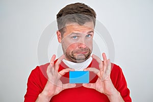 man looking displeased holding credit card in hands