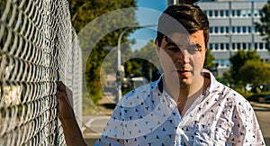 Man Looking Down Holding Fence