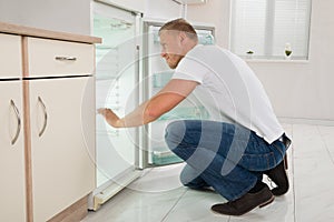 Man Looking Into An Empty Refrigerator