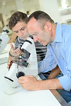 Man looking into eyepiece microscope