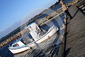 Man looking at fishing boat