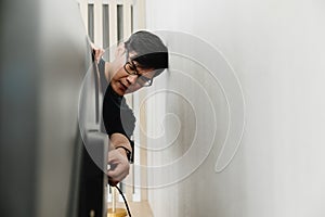 Muž hľadá opraviť kábel spojenie z televízia strana proti stena na 