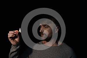 man looking at flame of burning