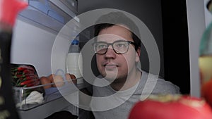 Man looking for the food, close up shot from refrigerator