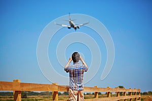 Man is looking at the glide path and landing plane photo