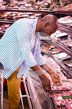 Man looking at goods in grocery section while shopping