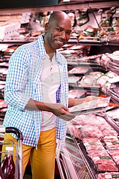 Man looking at goods in grocery section while shopping in supermarket