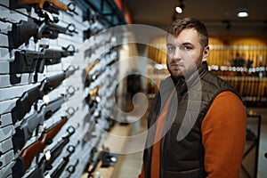 Man looking on handguns, showcase in gun shop