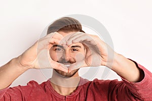 Man looking through heart made with his hands v