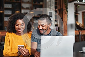 Man looking at his girlfriend`s mobile phone in cafe