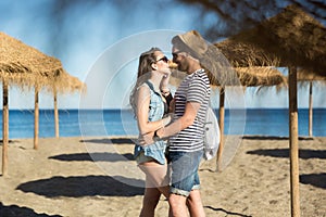 Man looking at his girlfriend touching his face on beach