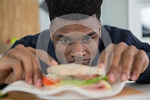 man looking at sandwhich