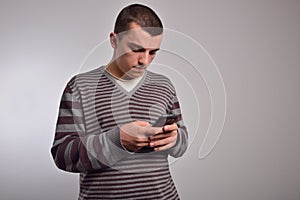 Man looking at his smart phone while text messaging