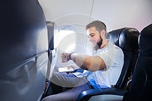 Man looking at his smart watch in airplane