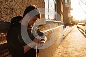 Man looking at his smartwatch in the city. Business concept