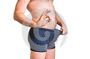 Man is looking in his underwear and pointing OK symbol