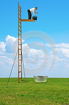 Man looking at his watch getting ready to jump off high dive into small tub of water representing risk taking courage and faith