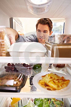 Man Looking Inside Fridge Filled With Food