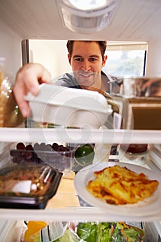 Man Looking Inside Fridge Filled With Food And Choosing Eggs