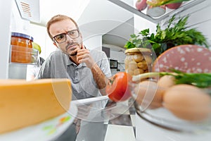 Man Looking Inside Fridge Full Of Food