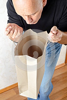 Man Looking Inside a Paper Bag