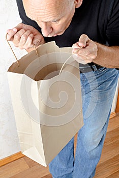 Man Looking Inside a Paper Bag