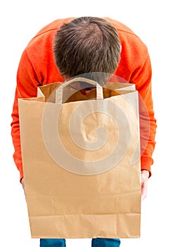 Man looking inside paper bag.