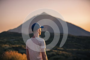 Man looking at landscape with Teide volcano at sunset