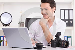 Man is looking at laptop with excitement. photo