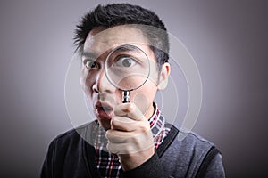 Man looking through a magnifying glass