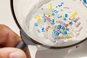 A man looking through a magnifying glass. water pollution and soil microplastic. macro photo